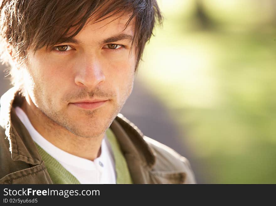 Portrait Of Young Man In Autumn Park At Camera