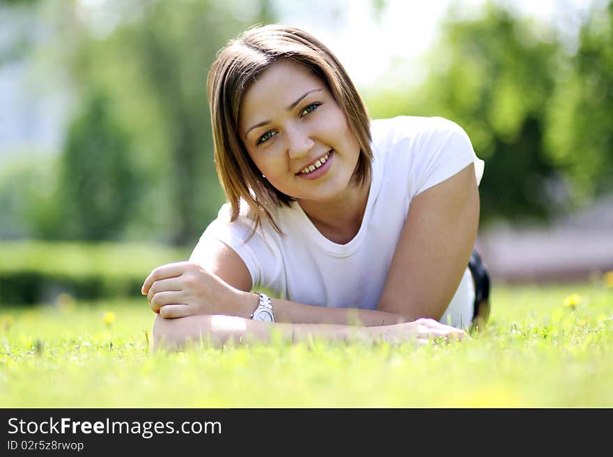 Cute young female lying on grass field at the park. Cute young female lying on grass field at the park