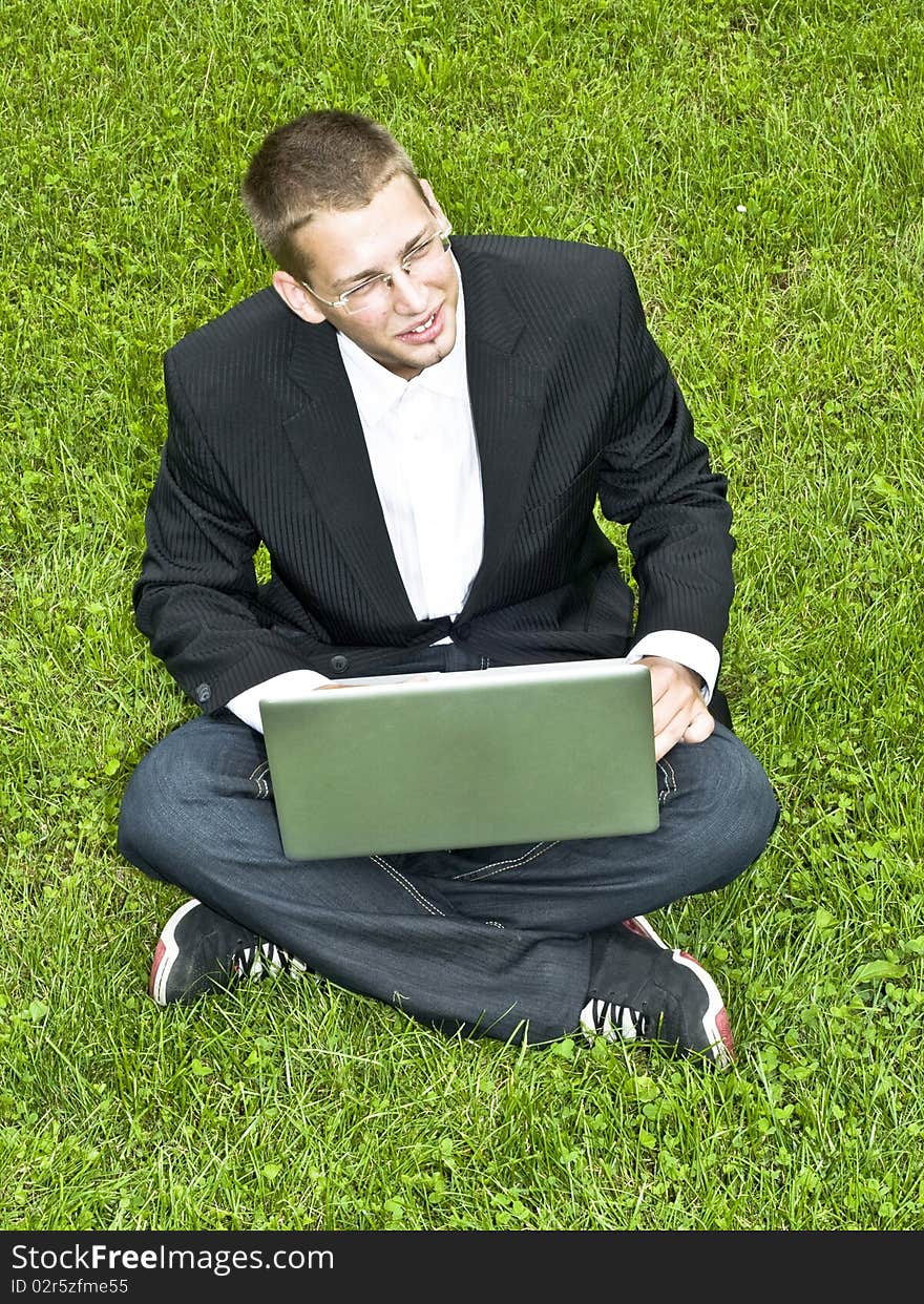 Young Businessman On The Grass With His Laptop