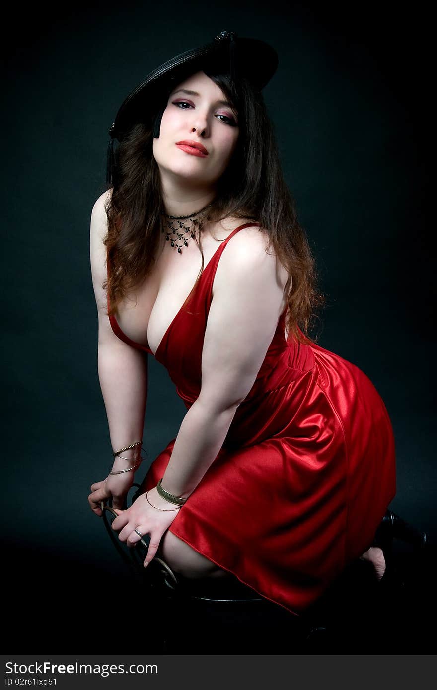 busty woman wearing vintage hat with tassles and low cut red dress. busty woman wearing vintage hat with tassles and low cut red dress