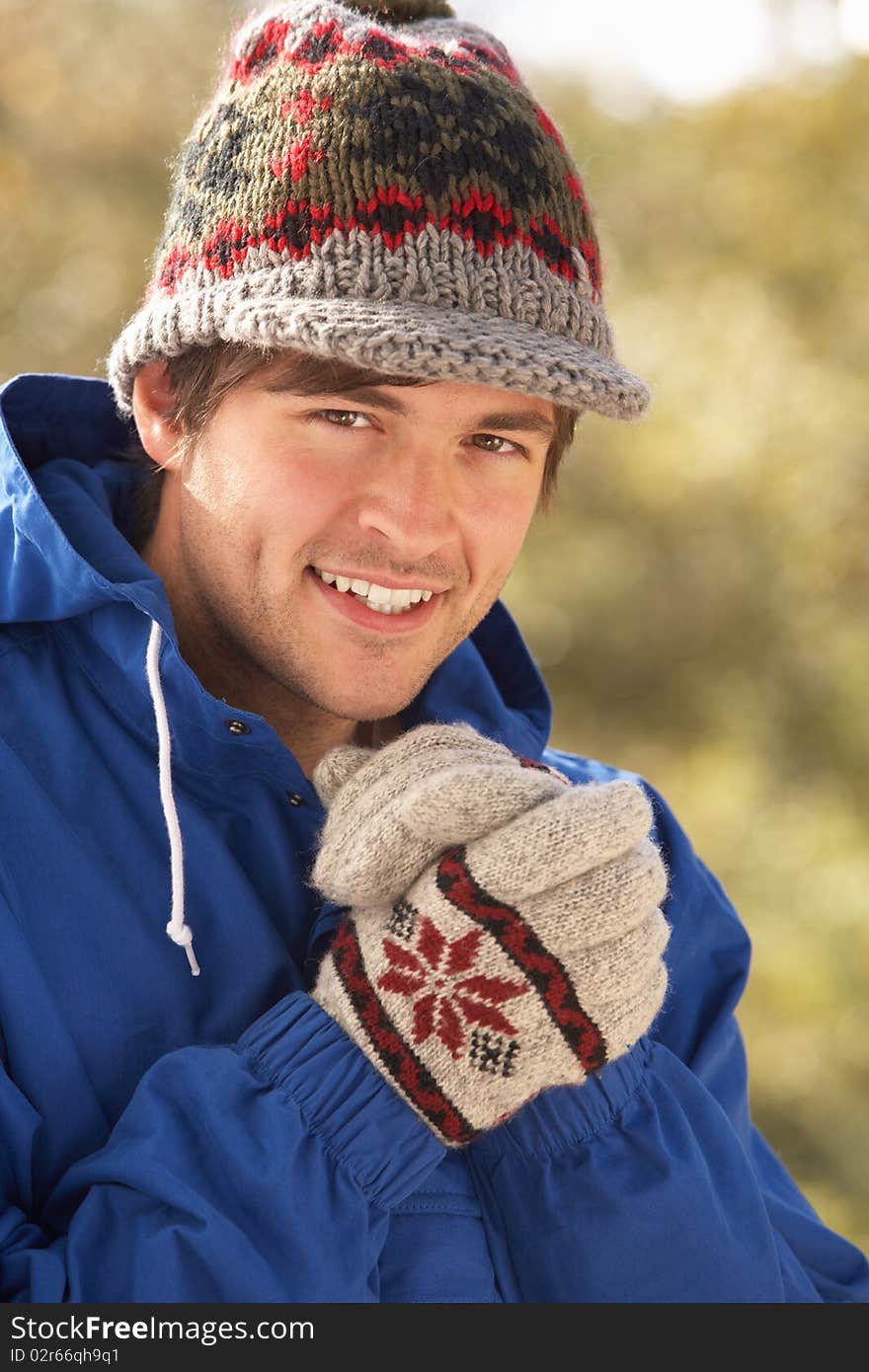 Young Man Relaxing In Autumn Landscape Smiling At Camera