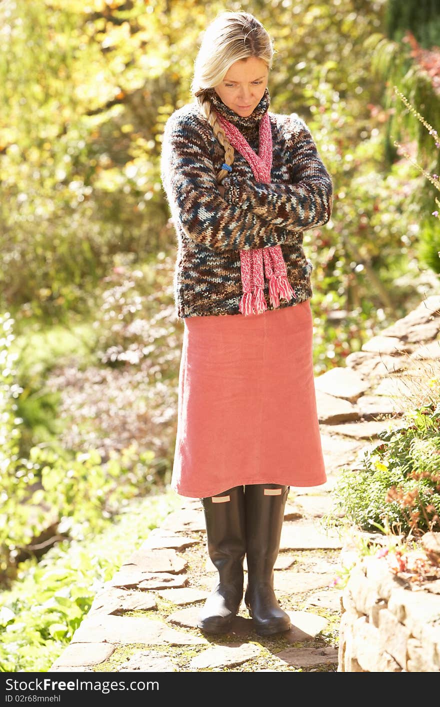 Full Length Portrait Of Young Woman Walking In Autumn Garden