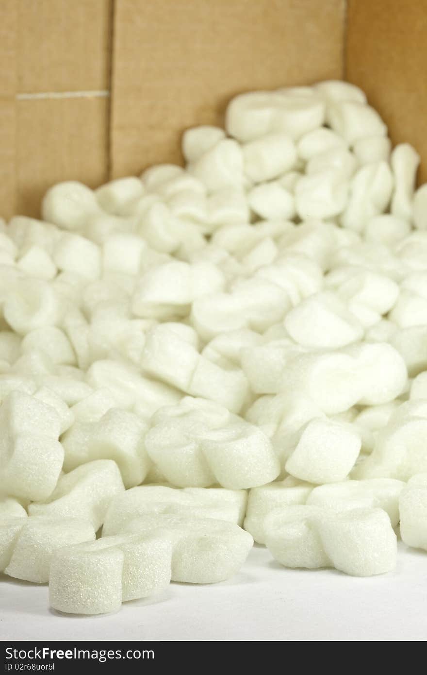 A closeup of packing peanuts spilling out of a cardboard box. A closeup of packing peanuts spilling out of a cardboard box