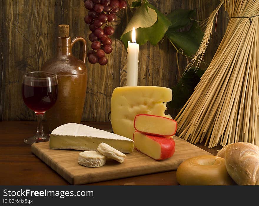 Bottle of wine with grapes , bagels, and cheese on a cheeseboard. Bottle of wine with grapes , bagels, and cheese on a cheeseboard