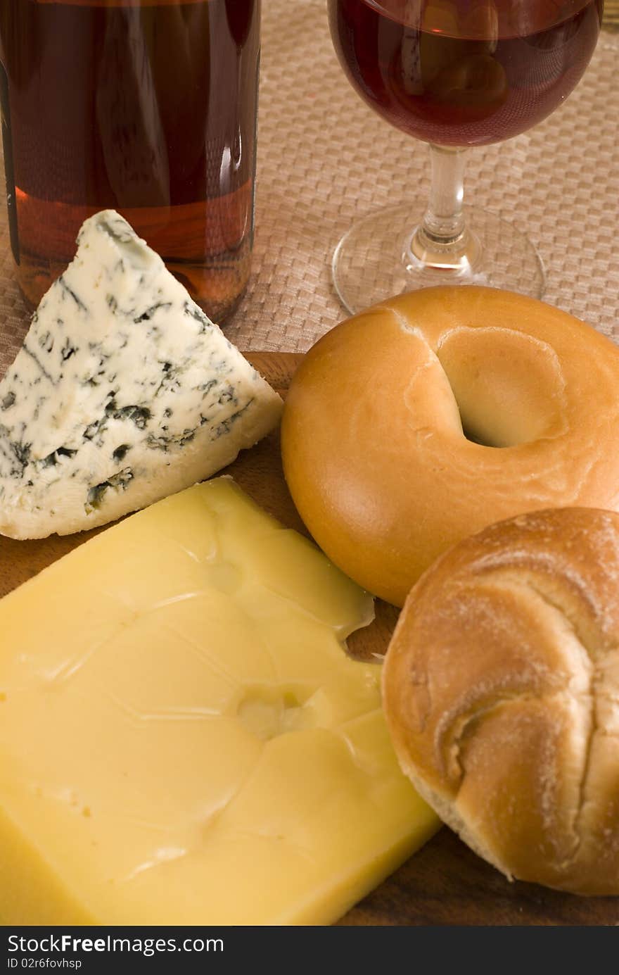 Bottle of wine with  bagels, and cheese on a cheeseboard. Bottle of wine with  bagels, and cheese on a cheeseboard