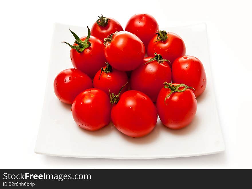 Tomatoes on white plate. Isolated on white background