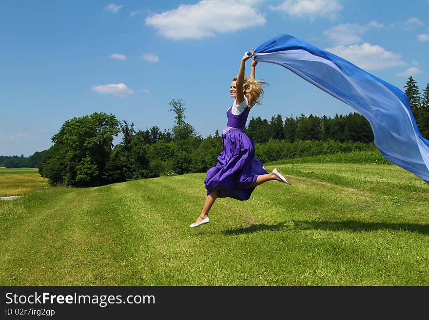 A bavarian girl jumping and waving flags