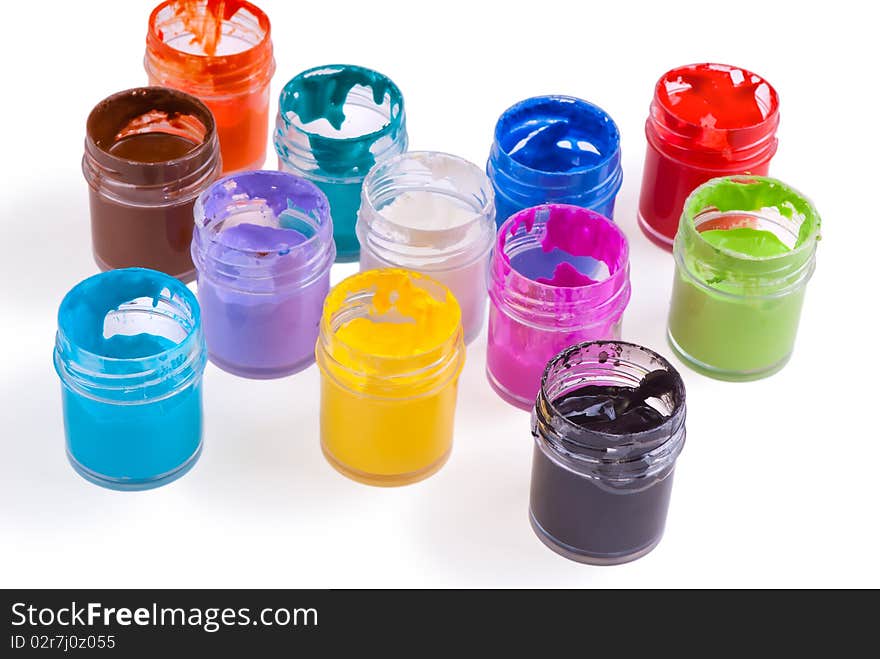 Watercolour pain in jars spilled on white background