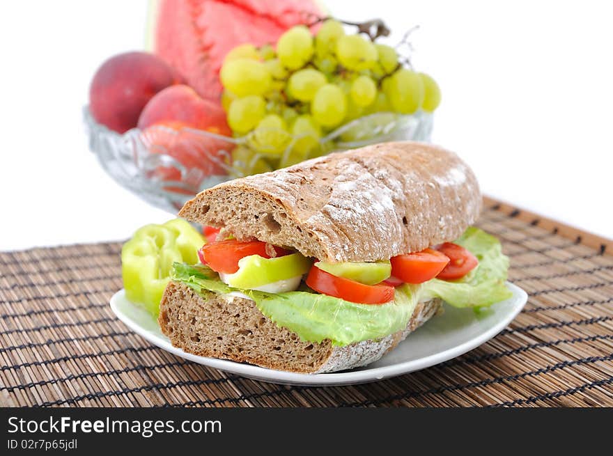 Diet brown baguette with vegetable and bow of fruits on background