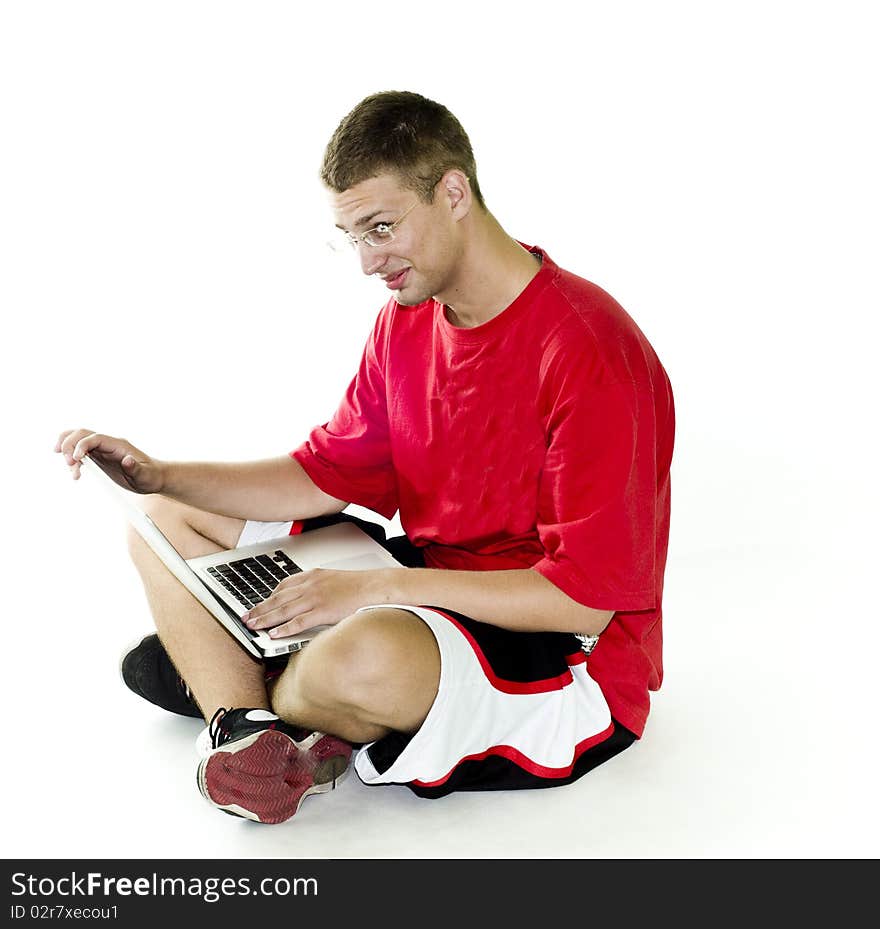 Young man smiling while working on laptop in red shirt, isolated on white background