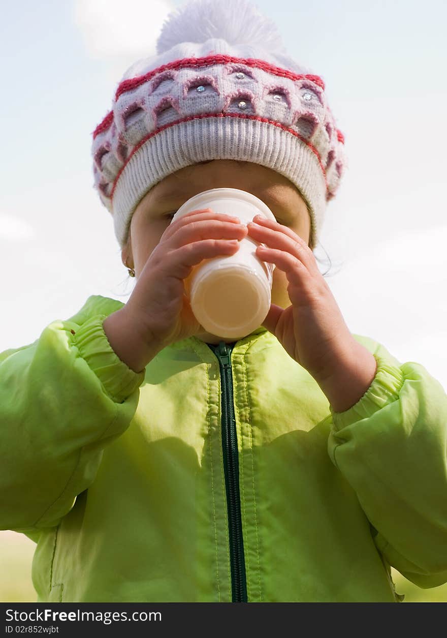 Girl drinking water against the sky