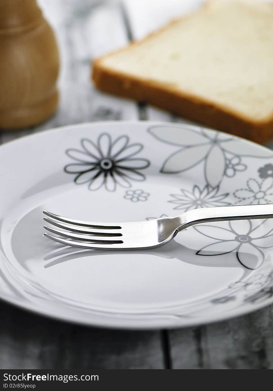 Served wooden table with empty plate and fork on it. Served wooden table with empty plate and fork on it