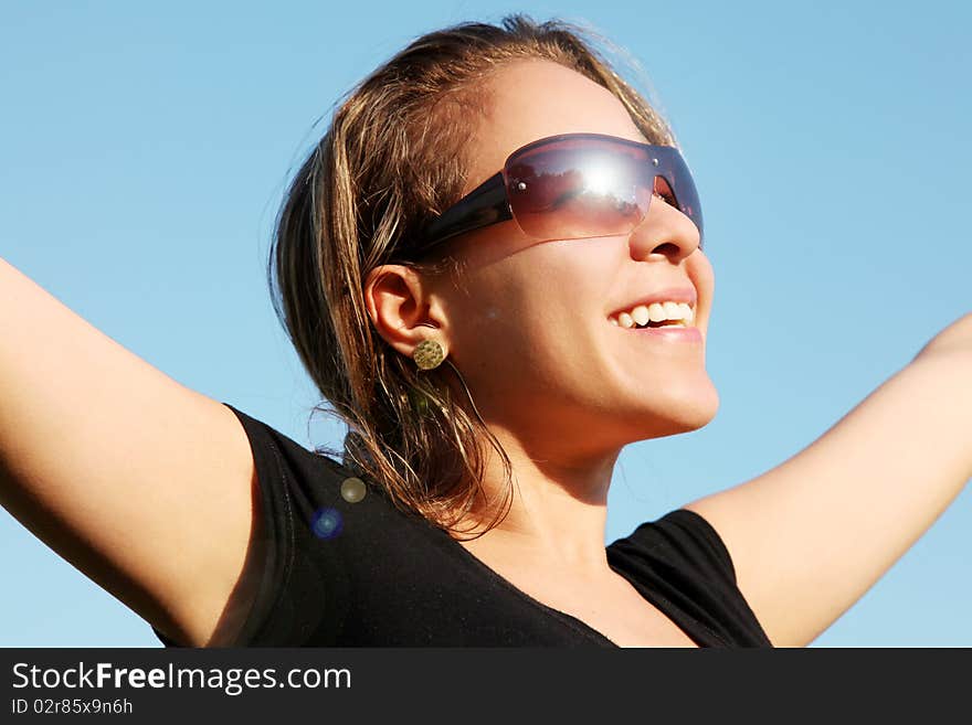 Woman looking at sun with lenses, hand outstretched over blue sky background. Woman looking at sun with lenses, hand outstretched over blue sky background