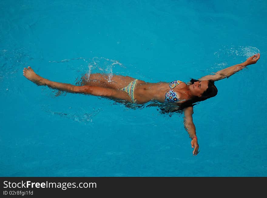 A girl is relaxing in a swimming pool. A girl is relaxing in a swimming pool