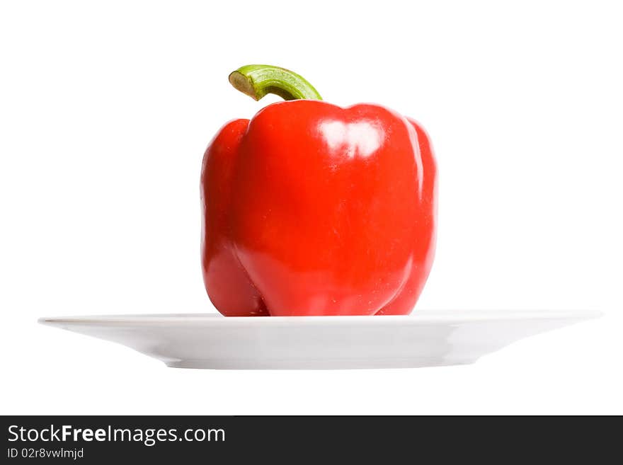 Red paprika on white plate. Isolated oh white background