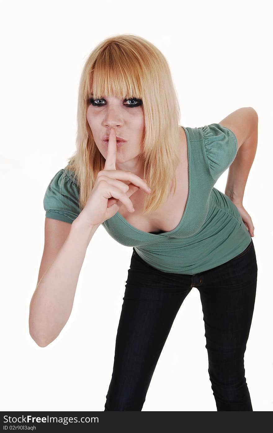 An beautiful woman, standing in the studio, bending forward and holding her finger over her mouth and asking for silence, on white background. An beautiful woman, standing in the studio, bending forward and holding her finger over her mouth and asking for silence, on white background.