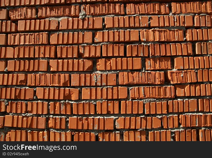 The red brick wall of a house, can be used as background. The red brick wall of a house, can be used as background