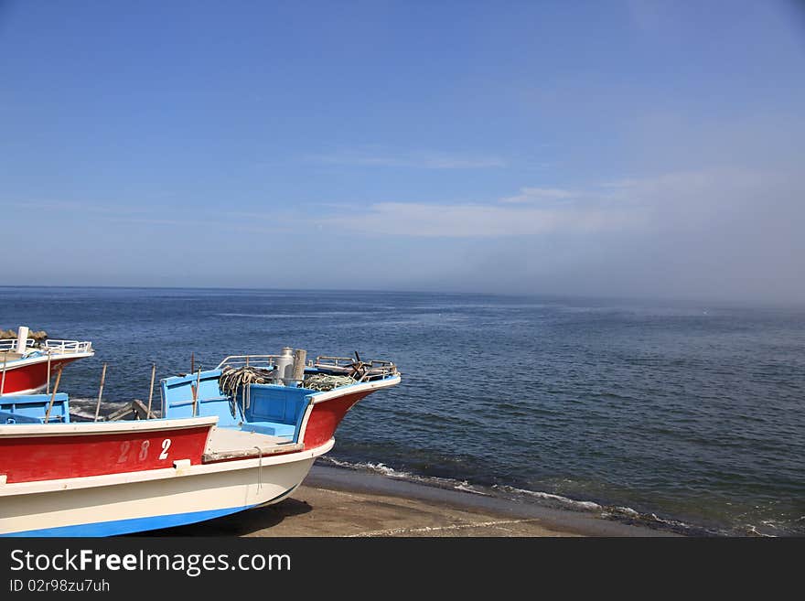 Fishing Boats on Shore on Clear Blue Sky Day