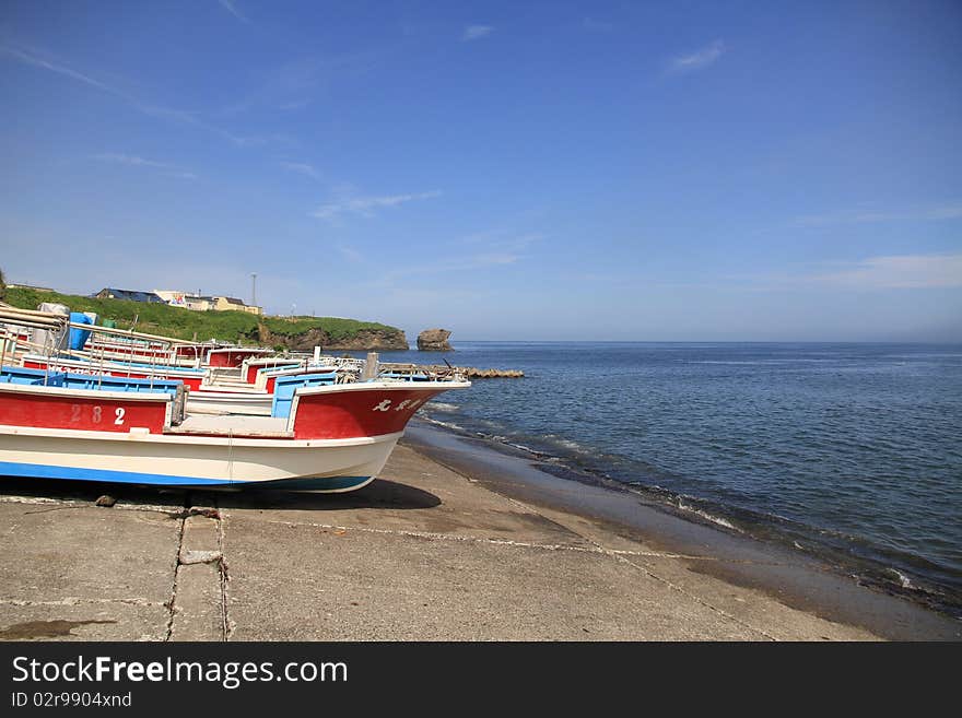 Fishing Boats on Shore on Clear Blue Sky Day