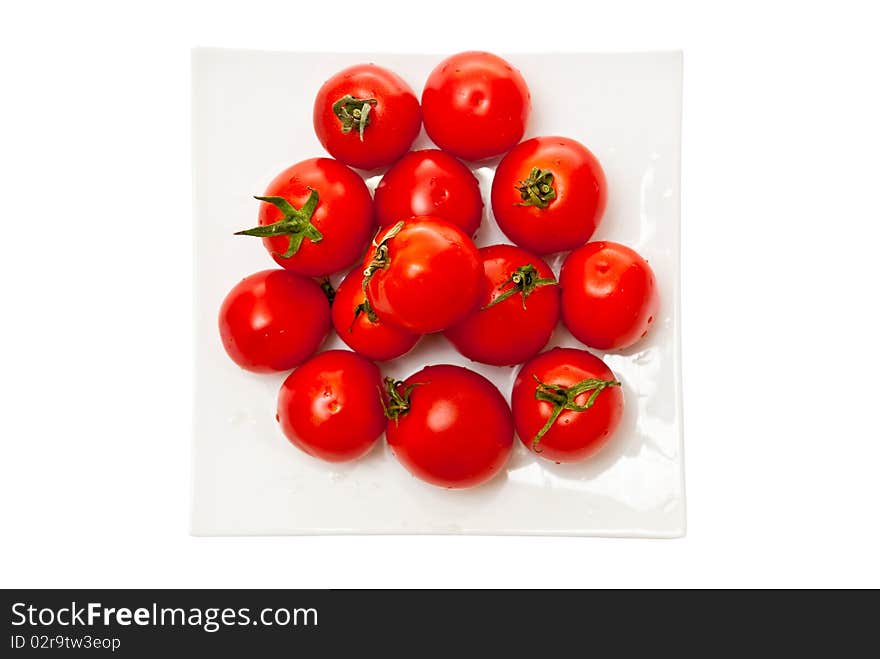 Fresh tomatoes on white plate. Isolated on white background