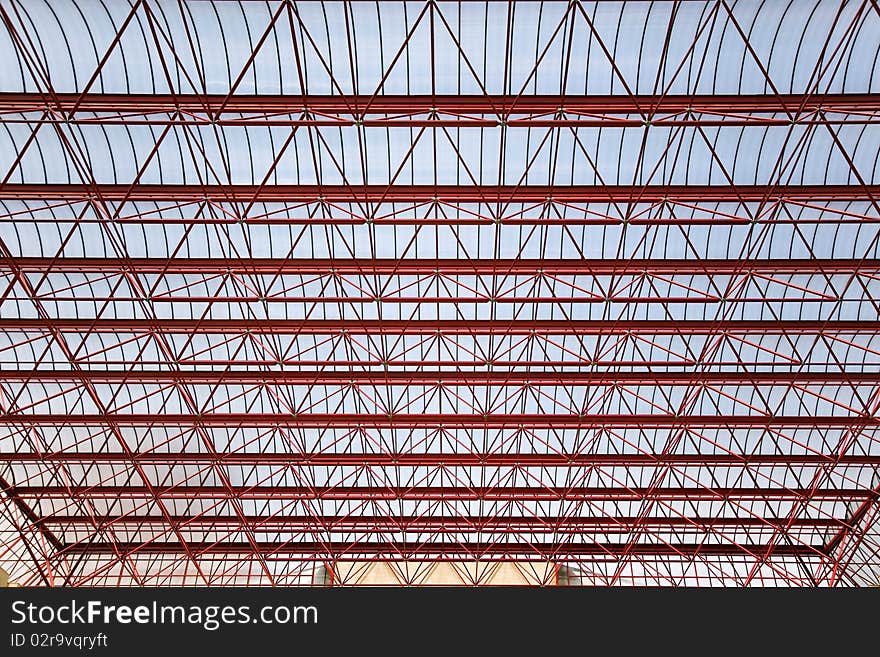 The big, modern roof collected from metal designs, covered with plastic, against the blue sky. The big, modern roof collected from metal designs, covered with plastic, against the blue sky