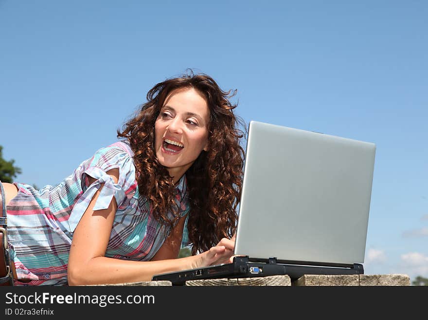 Woman using laptop computer on a pontoon. Woman using laptop computer on a pontoon