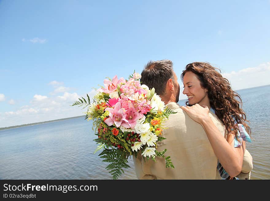 Man surprising woman with bunch of flowers. Man surprising woman with bunch of flowers