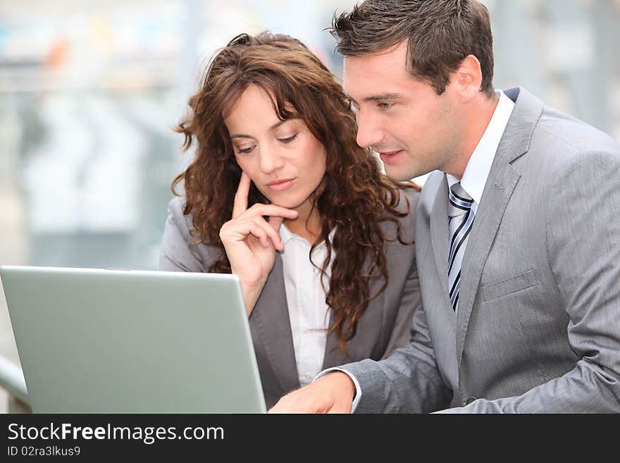 Business people working on laptop computer outside. Business people working on laptop computer outside