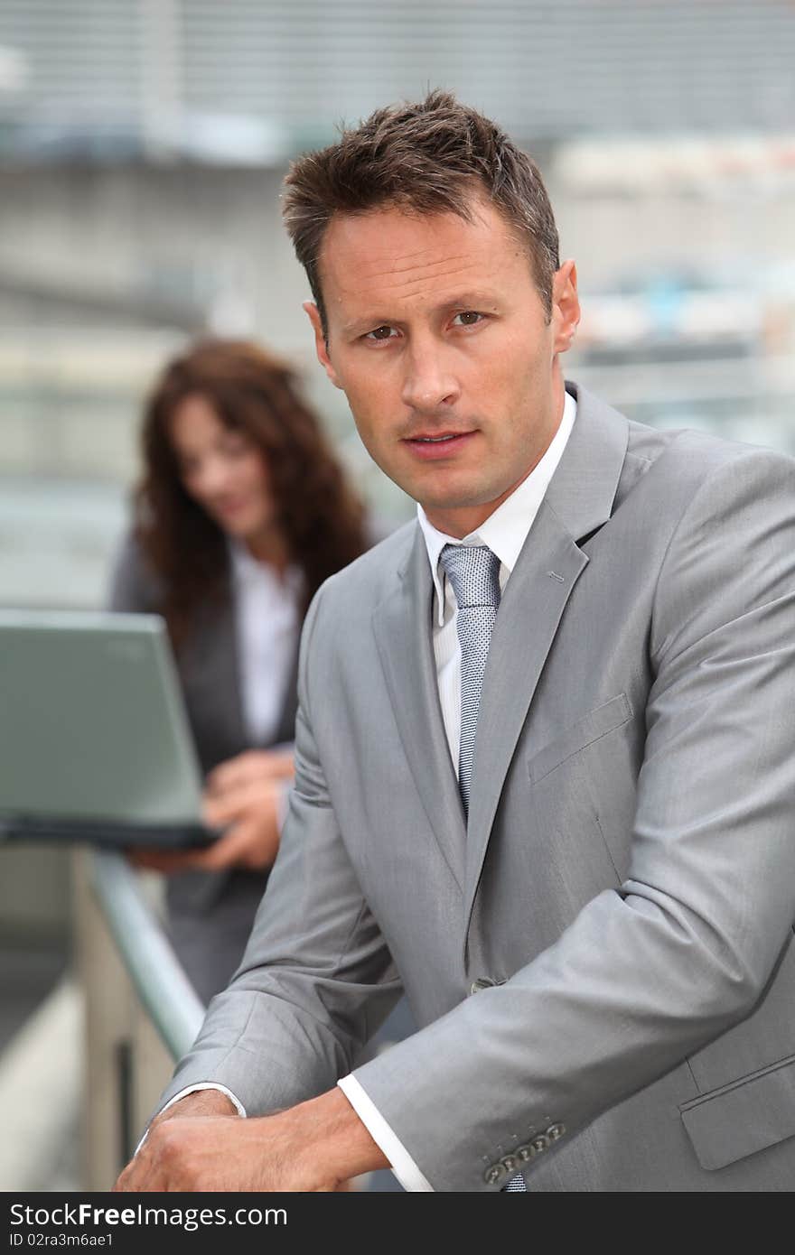 Businessman standing in front of offices outside. Businessman standing in front of offices outside