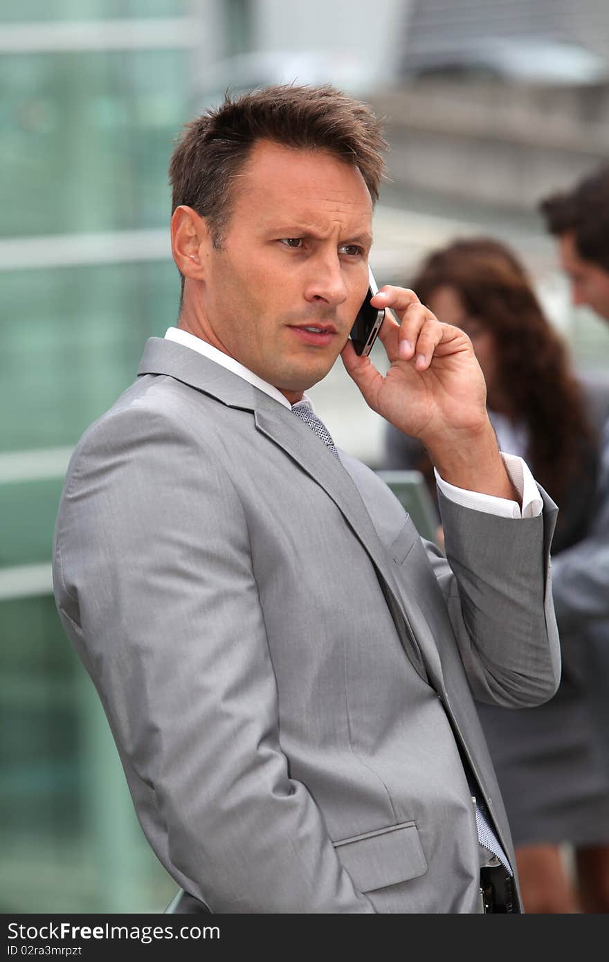 Businessman standing in front of offices outside. Businessman standing in front of offices outside