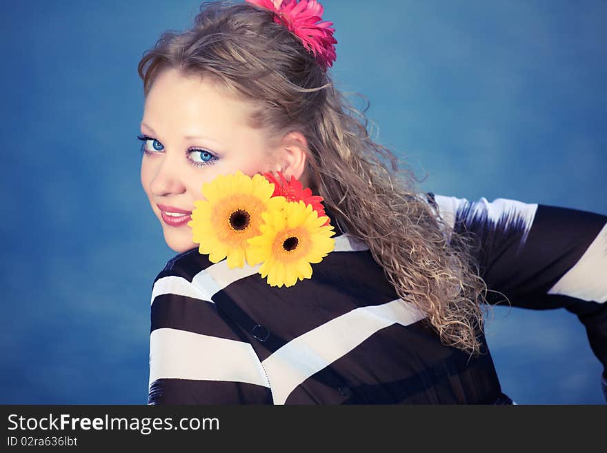 Beautiful woman with flowers. Sea water on background. Beautiful woman with flowers. Sea water on background