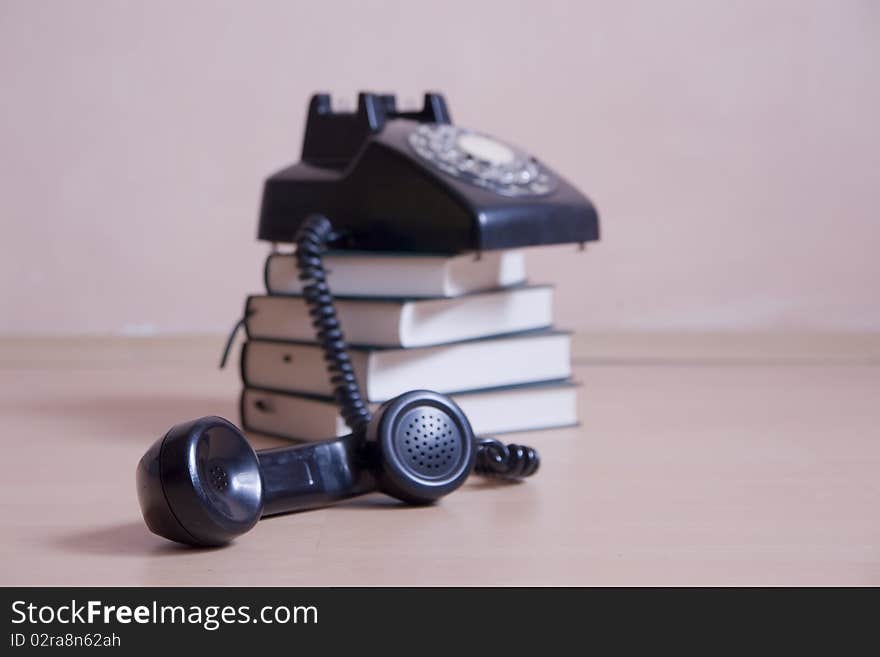 Stack Of Books With Vintage Telephone On Top