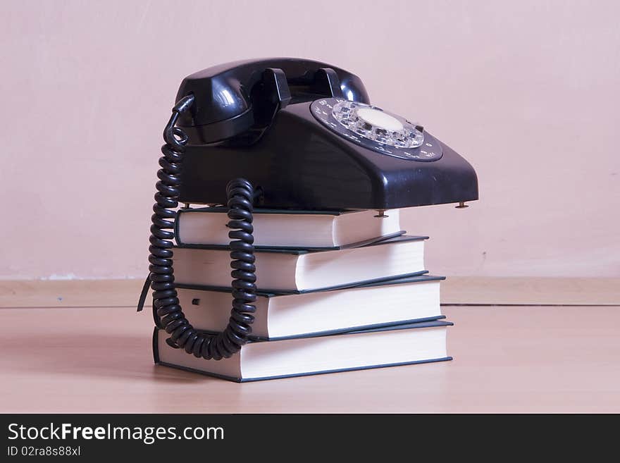 Stack Of Books With Vintage Telephone On Top