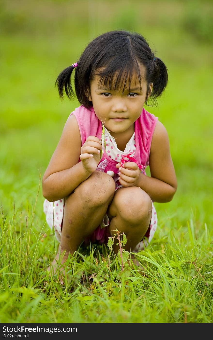 Cute Asian Girl Holding A Grasshopper