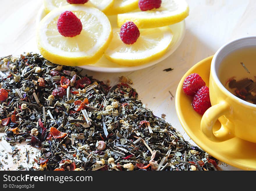 Cup with herbal tea, alongside lemon and dry tea