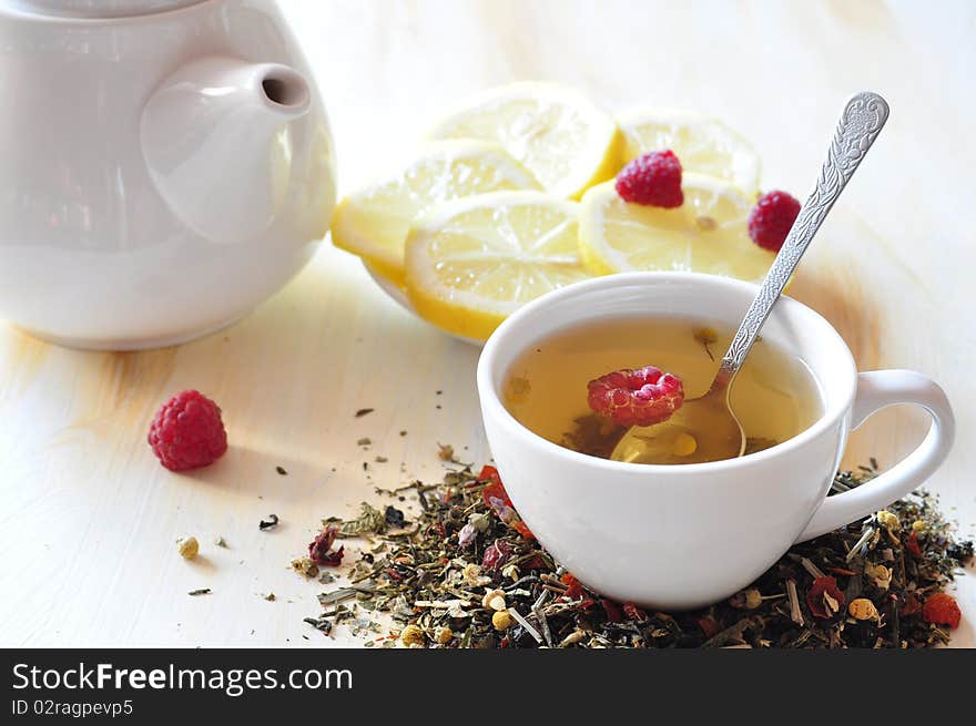 Cup with herbal tea, alongside lemon and dry tea