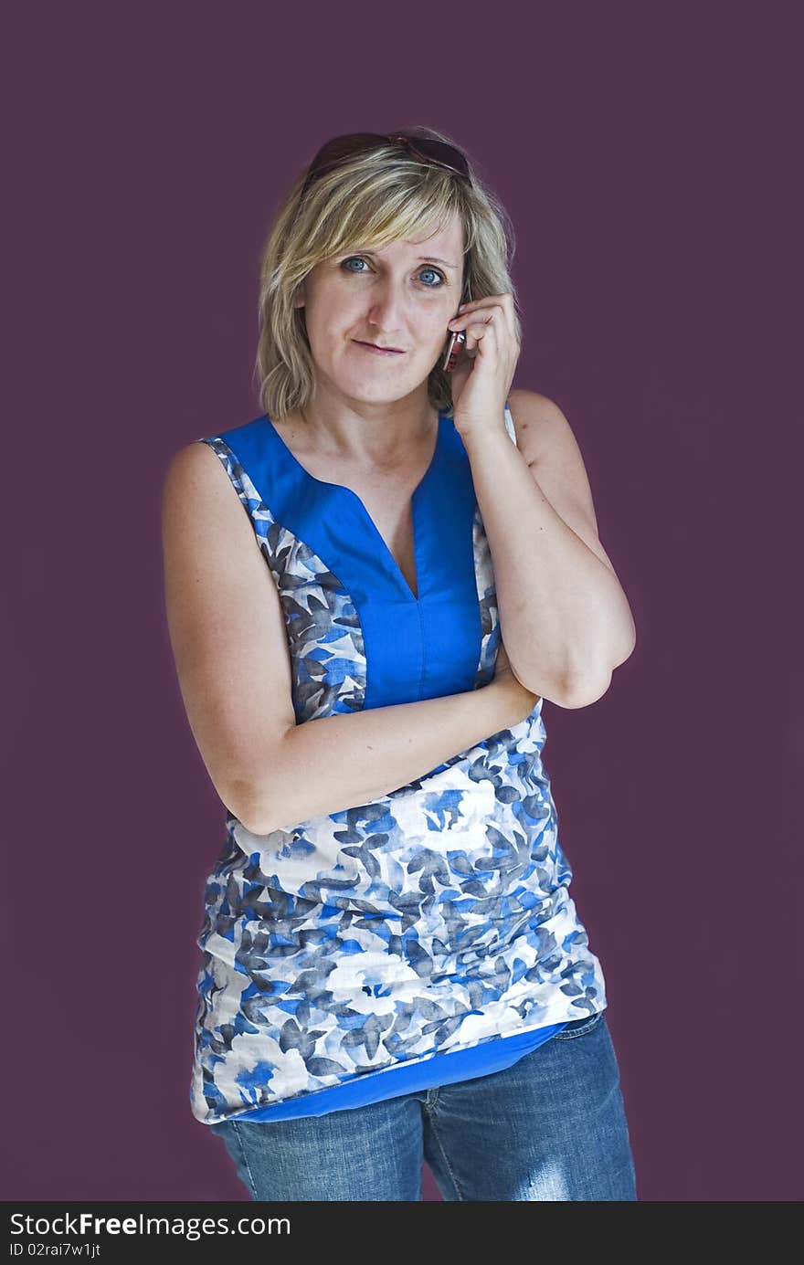 White woman talking on moblie phone on violet background. White woman talking on moblie phone on violet background