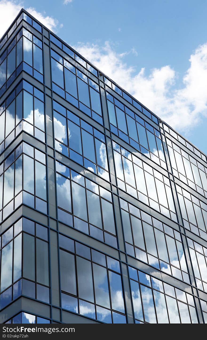 Modern glass building in perspective reflecting cloudy sky. Modern glass building in perspective reflecting cloudy sky