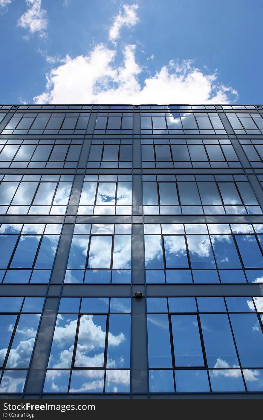 Modern glass building in perspective reflecting cloudy sky. Modern glass building in perspective reflecting cloudy sky