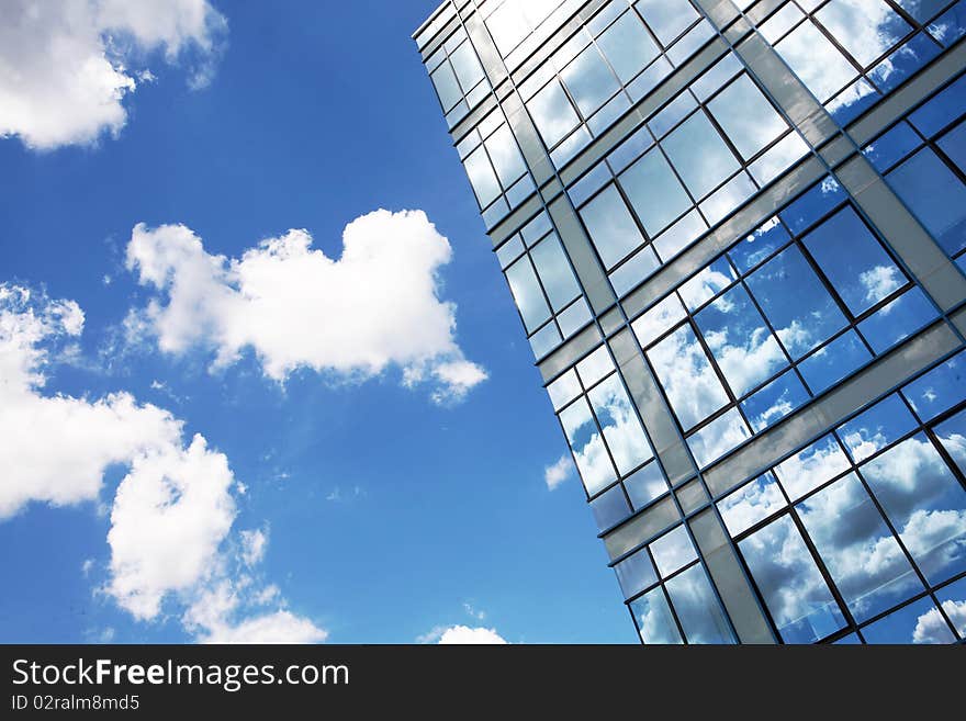 Modern glass building in perspective reflecting cloudy sky. Modern glass building in perspective reflecting cloudy sky