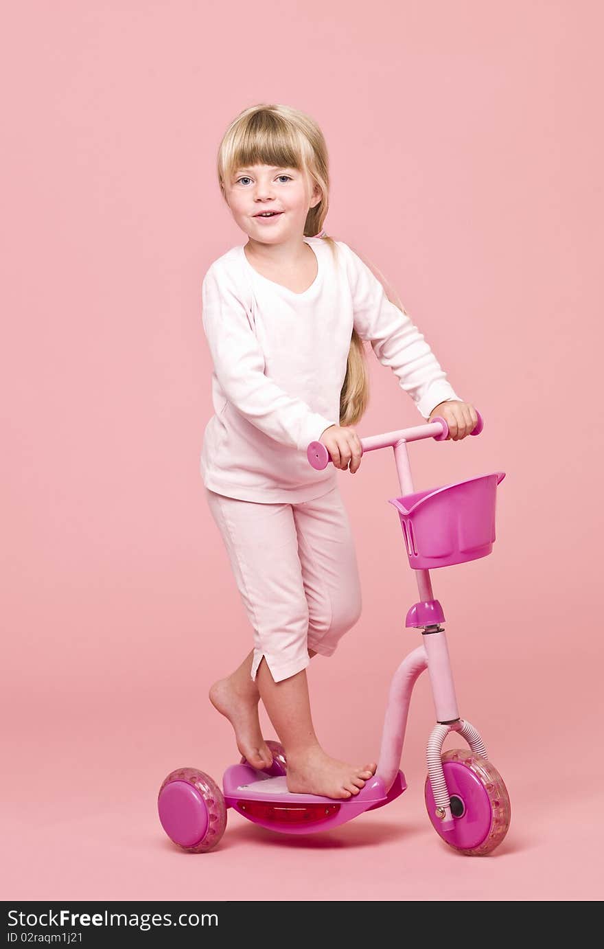 Angry girl ironing clothes towards pink background