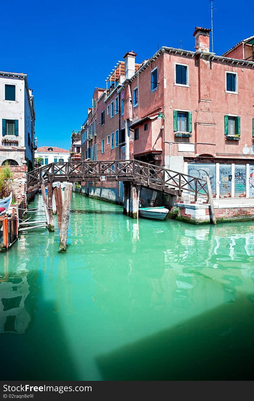 View of beautiful colored Venice canal with bridge and houses standing in water, Italy. View of beautiful colored Venice canal with bridge and houses standing in water, Italy