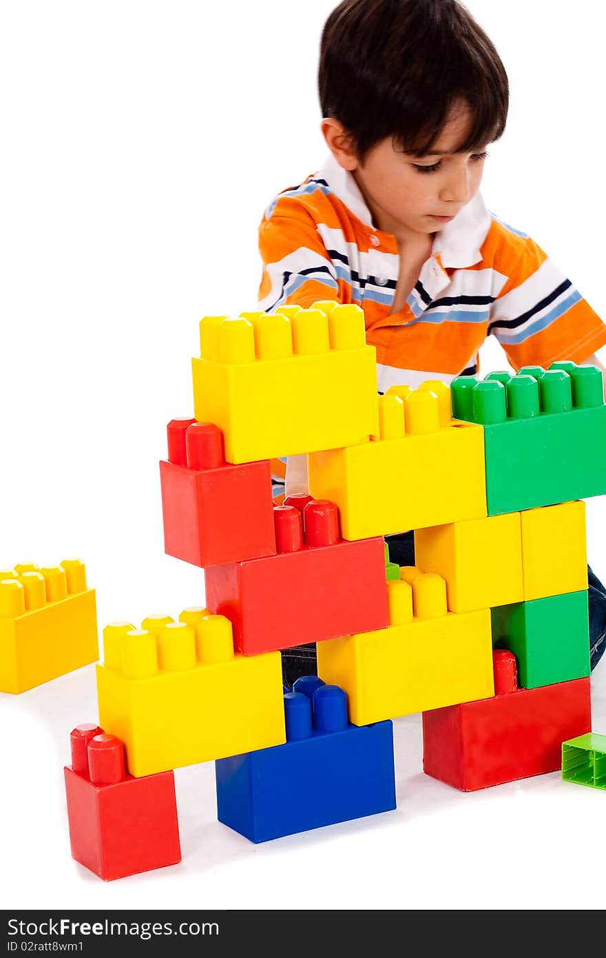 Young boy playing with building blocks on white background