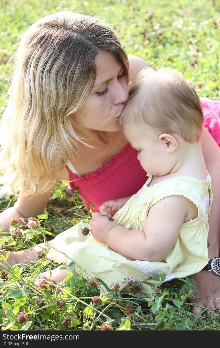 The mum gently kisses the daughter. The mum gently kisses the daughter