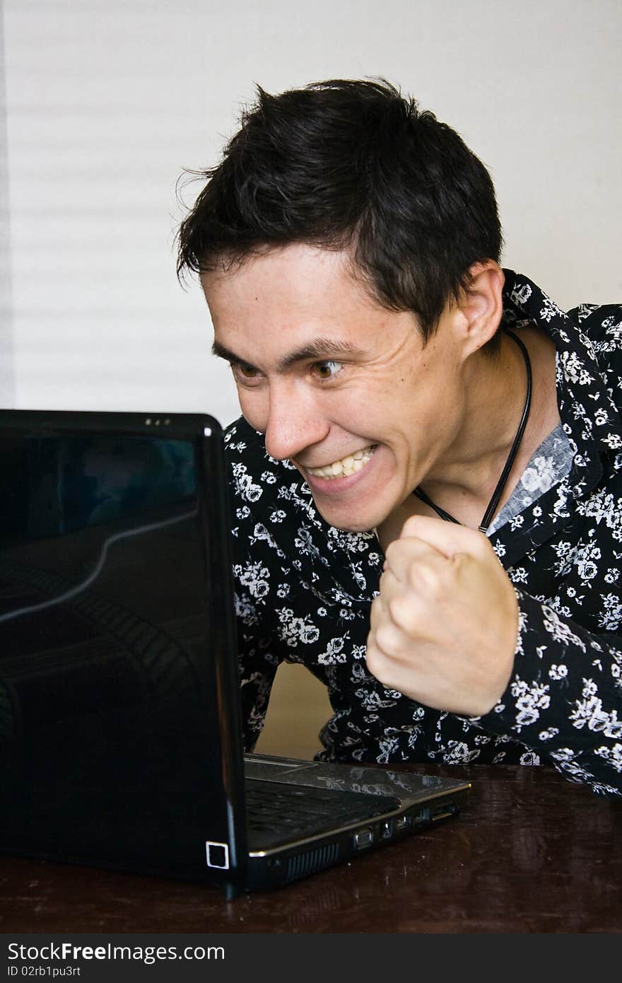 Man rejoices in what is happening on your computer monitor. Man rejoices in what is happening on your computer monitor