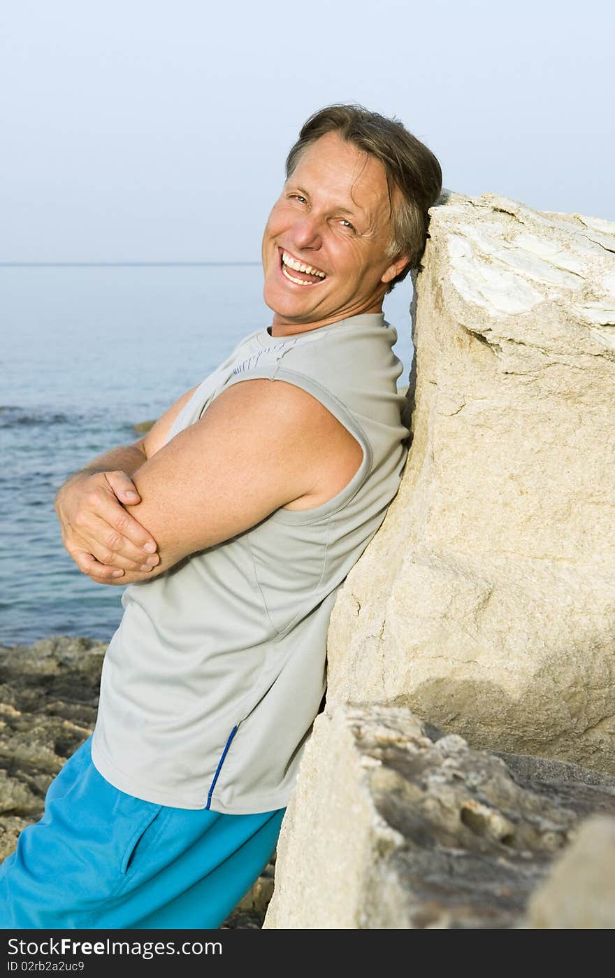 A color portrait photo of a happy laughing mature man in his forties relaxing at the beach. A color portrait photo of a happy laughing mature man in his forties relaxing at the beach.