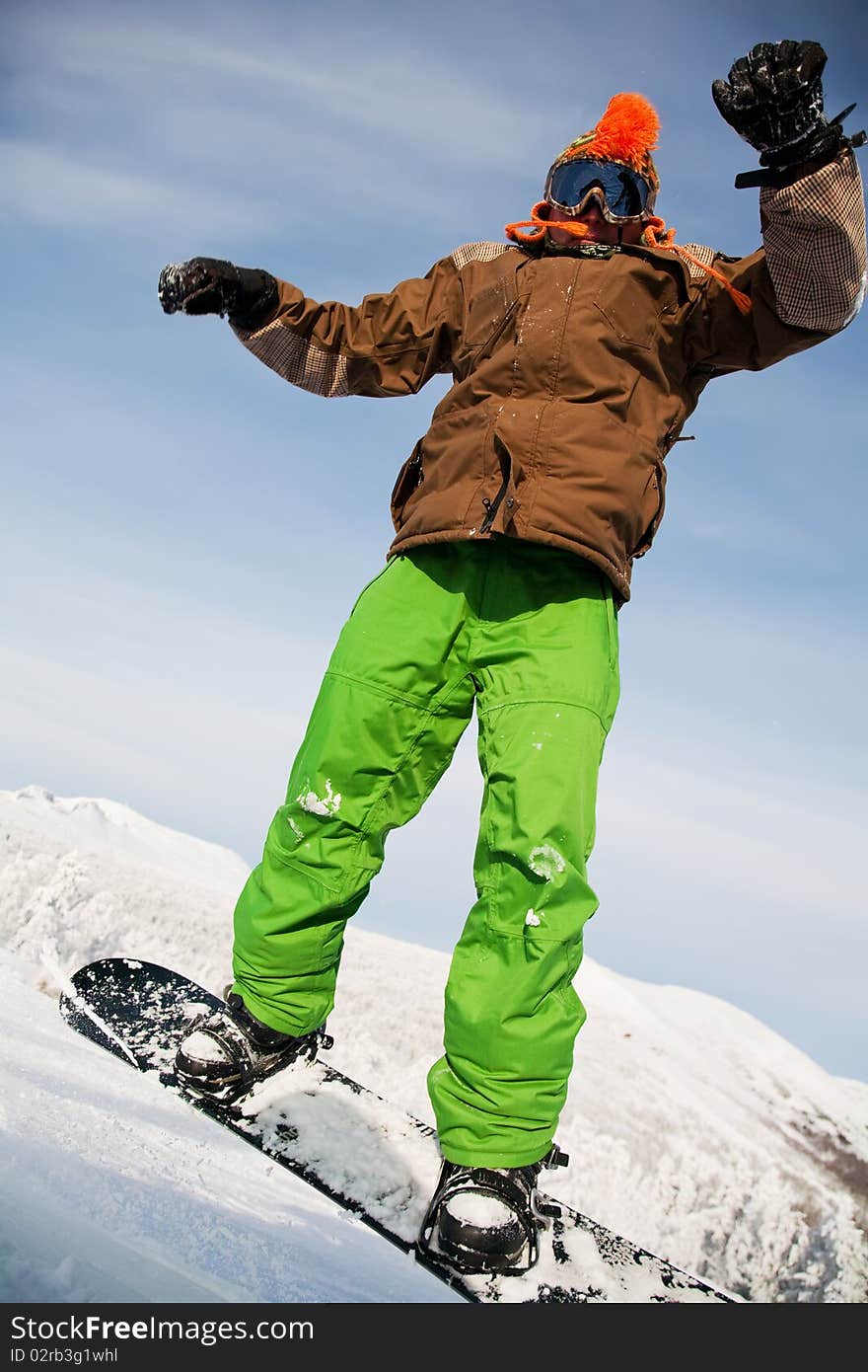 Snowboarder doing a toe side carve with deep blue sky in background