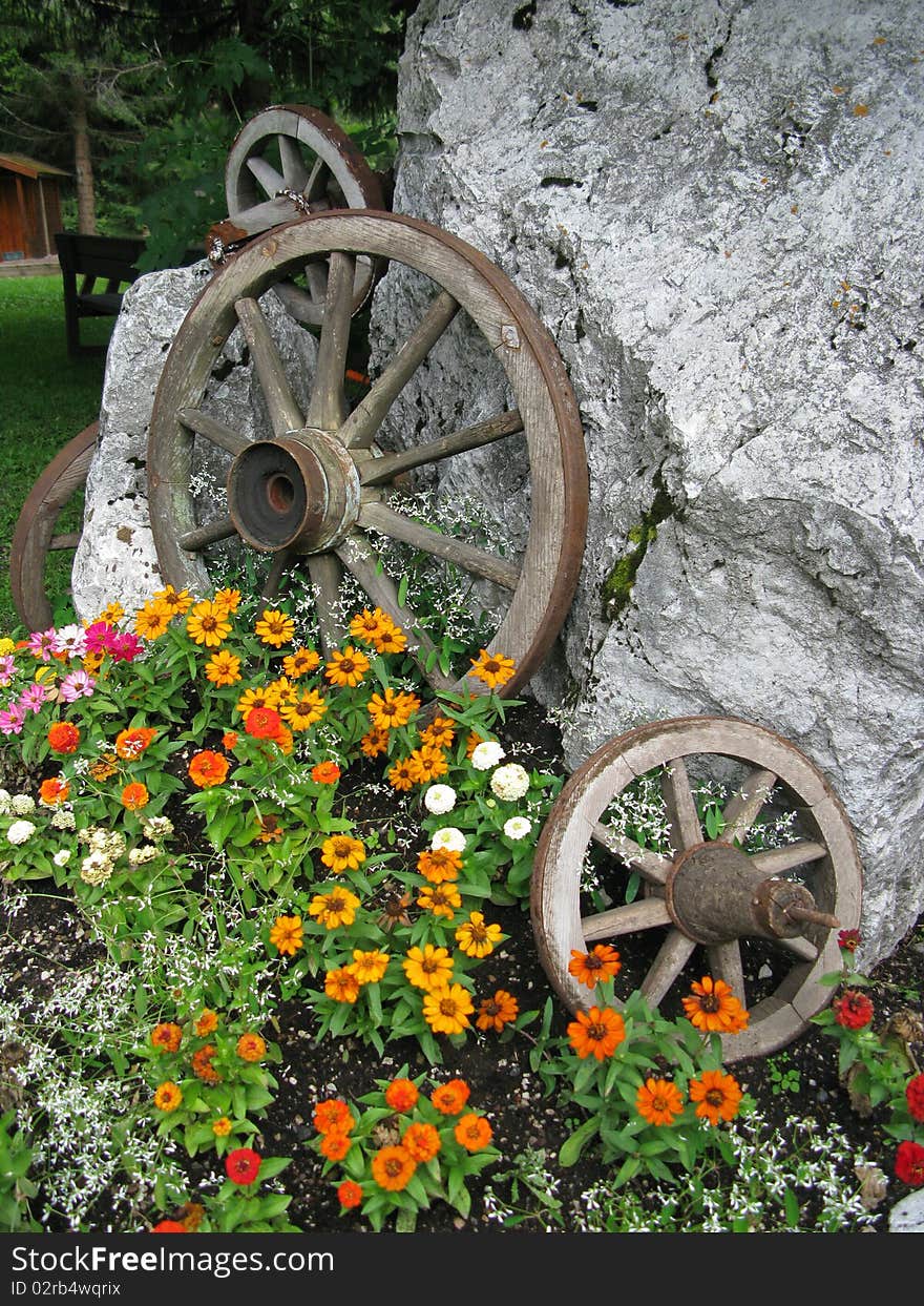 Ancient cart wheels used as decoration with flowers. Ancient cart wheels used as decoration with flowers