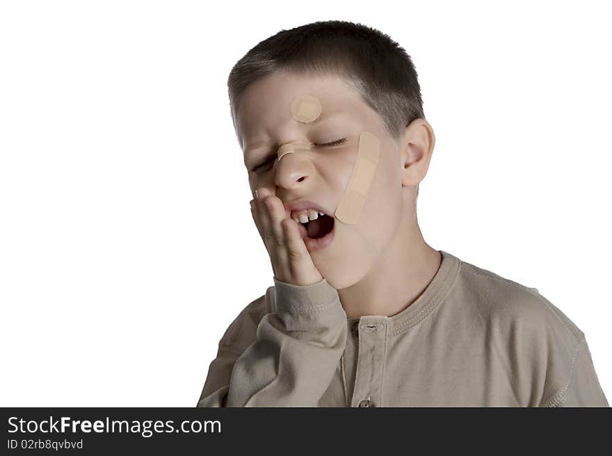 Young boy with band aids on face and suffering expression, studio shot isolated on white background. Young boy with band aids on face and suffering expression, studio shot isolated on white background