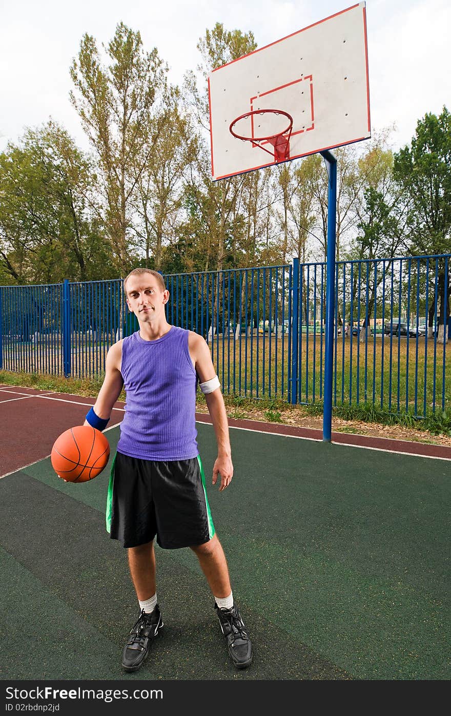 Young men playing street basketball at court playground